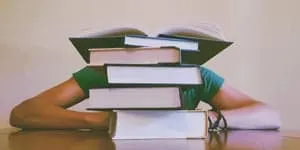 student drowning in books