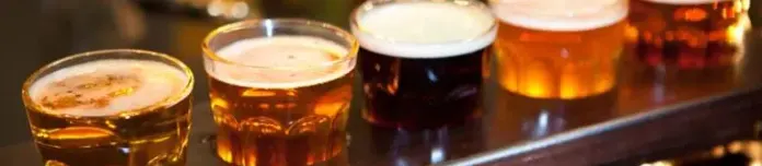 Row of beer glasses symbolizing different stages of alcohol use and addiction.