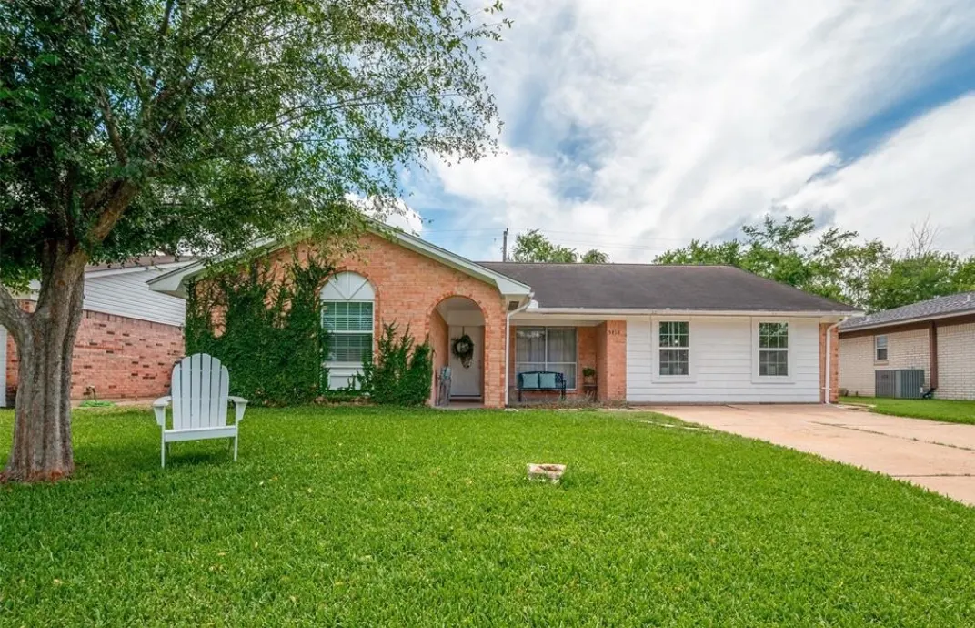 The brick exterior and front lawn of a Houston sober living house