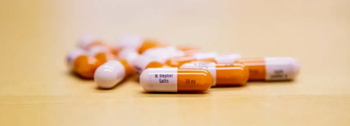 Prescription opioid capsules on a table representing the risk of misuse and addiction.